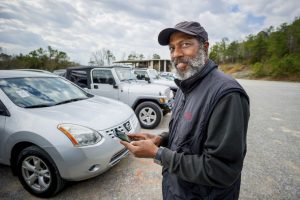 Dealer looks up Car Dealership Floor Plan on his phone