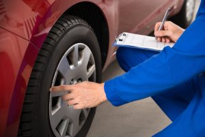 Mechanic looking at a vehicle to determine if it needs to go through the reconditioning process