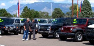 Dealership owner walking his lot with a customer looking at cars on his dealer floorplan.