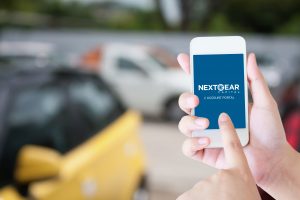 dealer on car lot using NextGear Capital's account portal on their phone as their auto floor plan lending solution